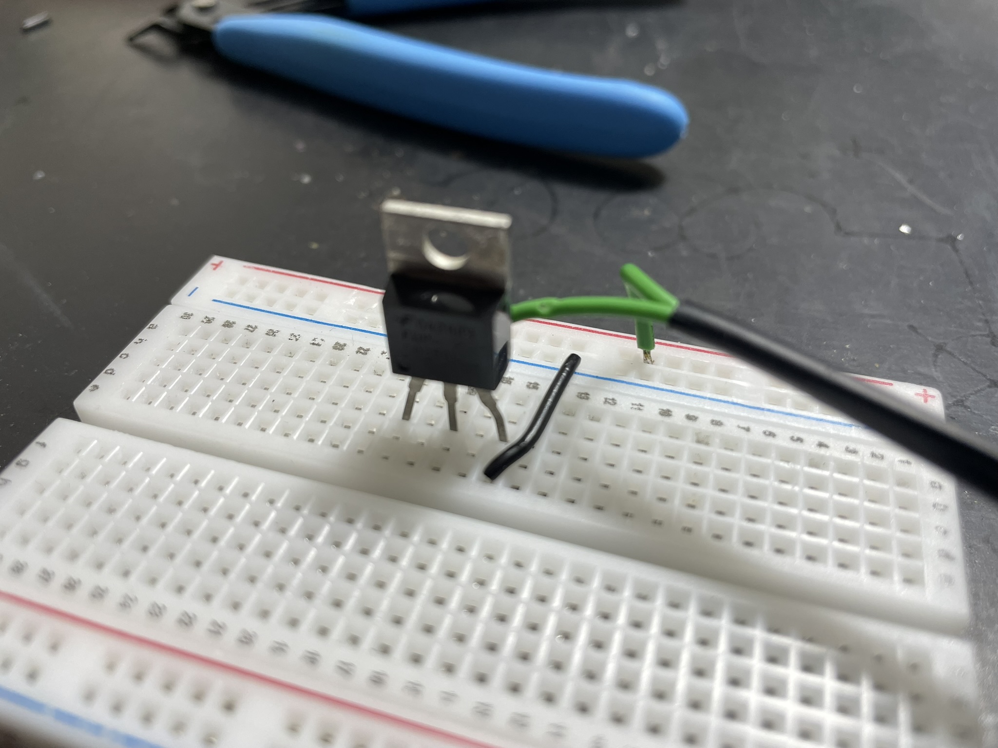 A breadboard with electronic components and jumper wires for prototyping or repairing a circuit.