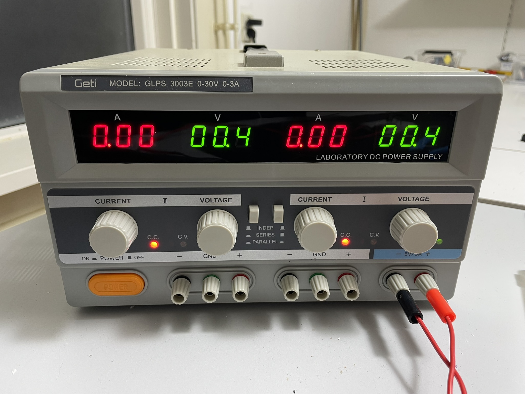 An electronic device with a digital display and controls requires external power through separate header pins.