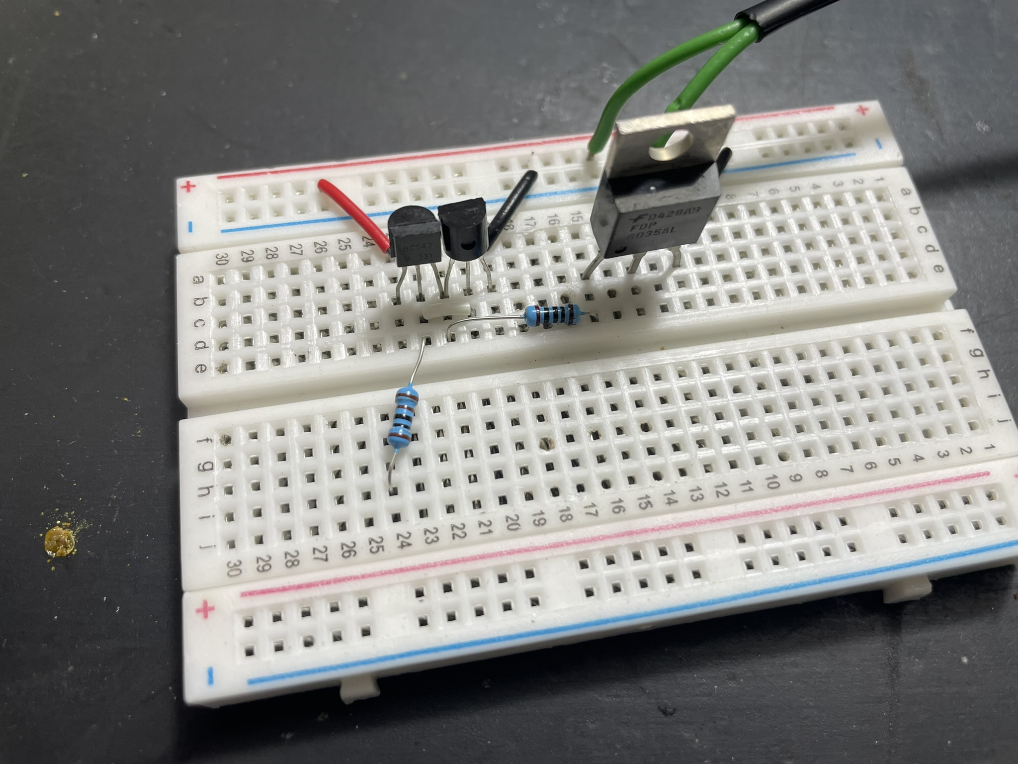 A breadboard with electronic components and jumper wires, featuring resistors and LEDs connected to a power supply.