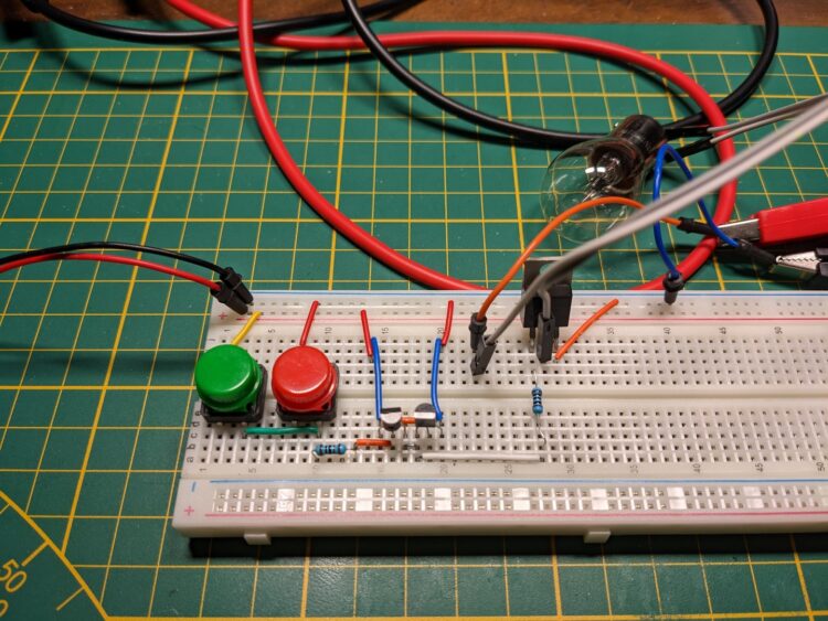 From left to right. Two buttons providing a high or low signal to a classic push-pull signal, which amplifies the current and then switches a low side MOSFET.