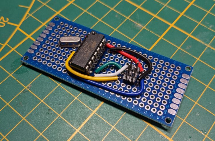 An ATTINY84 in a socket on a prototyping board with ICSP header and a crystal for clock
