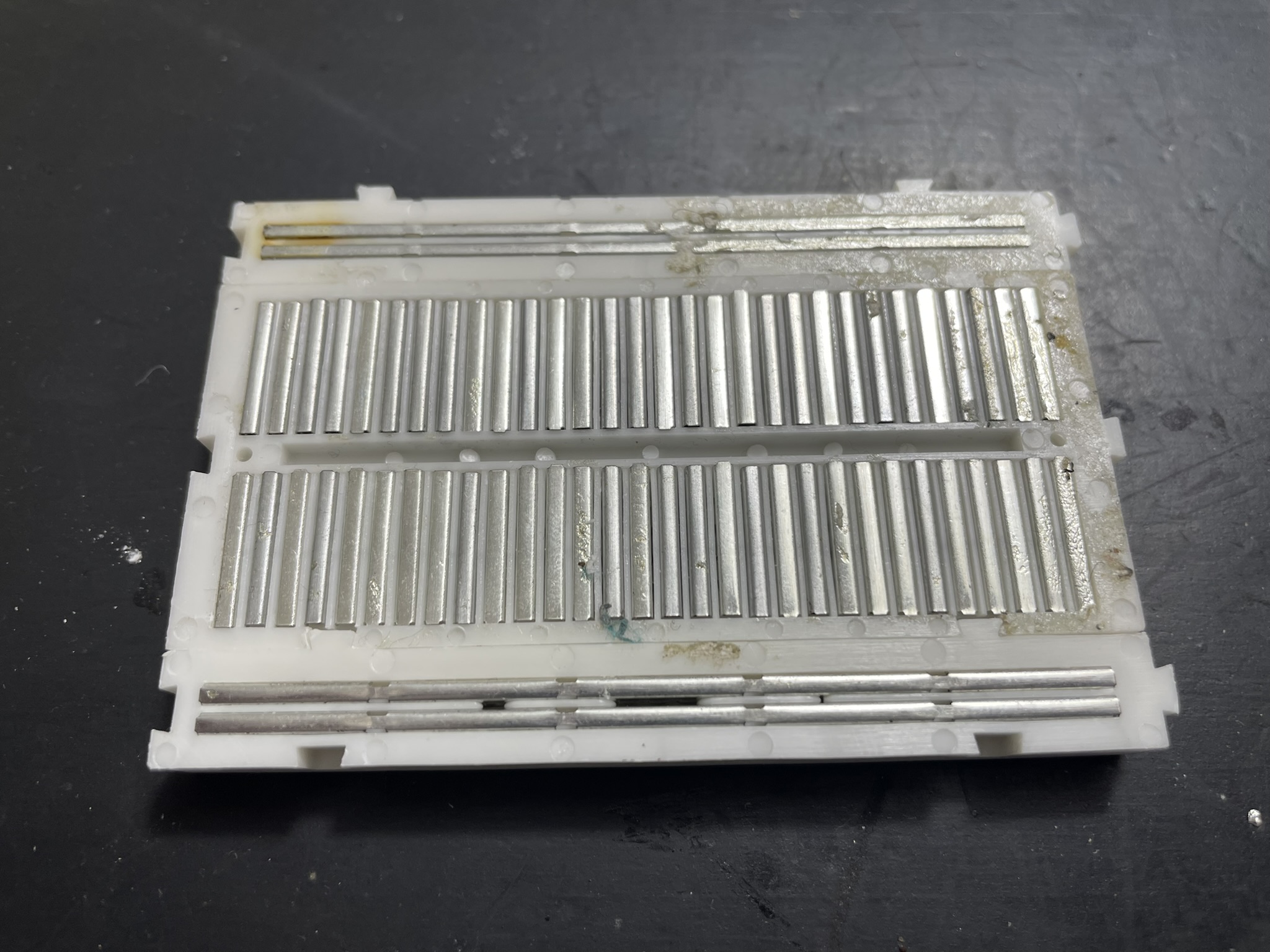 Backside of classic electronics prototyping breadboard, shows the connections