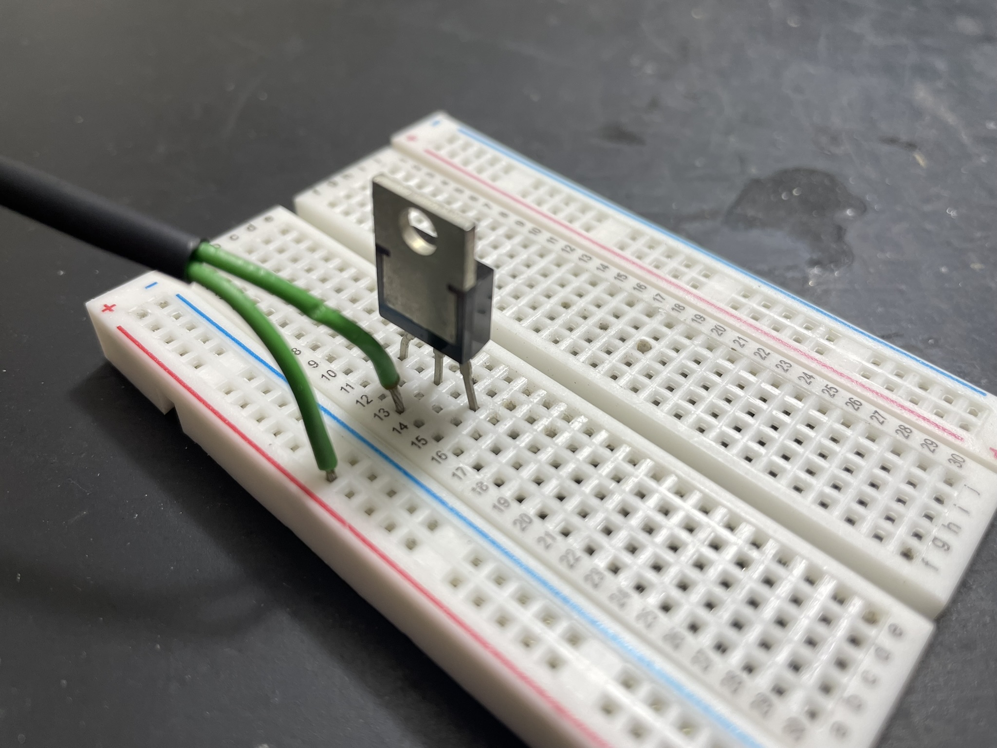 Low-side switching circuit for bicycle light with 30A capability, using small LED and resistors on breadboard