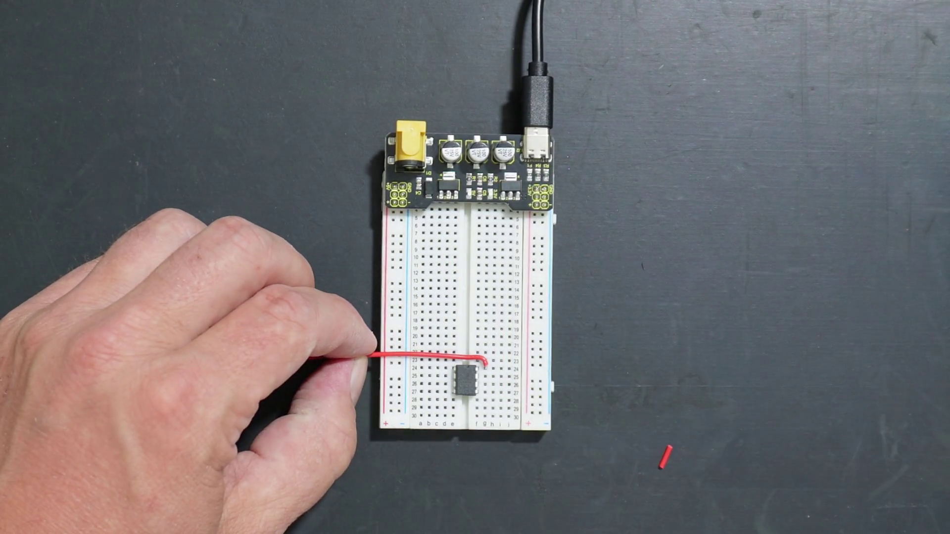 Adding wires on a breadboard with LM358 and power supply.