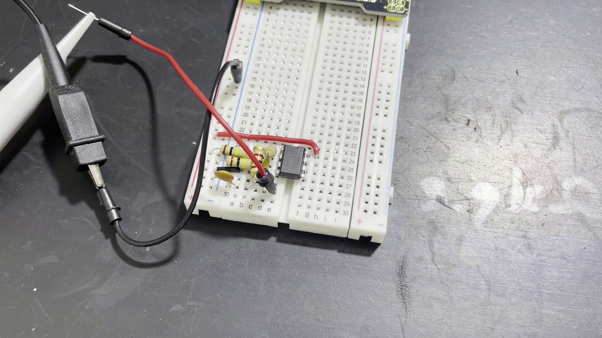 Oscilloscope wires attached to a oscillator circuit on a breadboard.